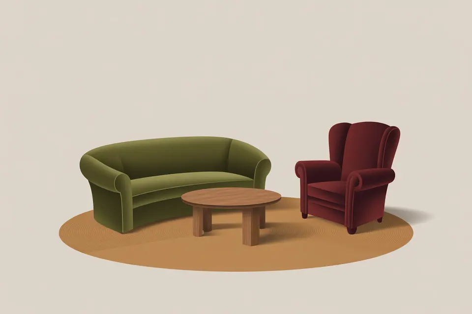 An olive sofa, a burgundy wingback chair and a low round table on an oval rug.